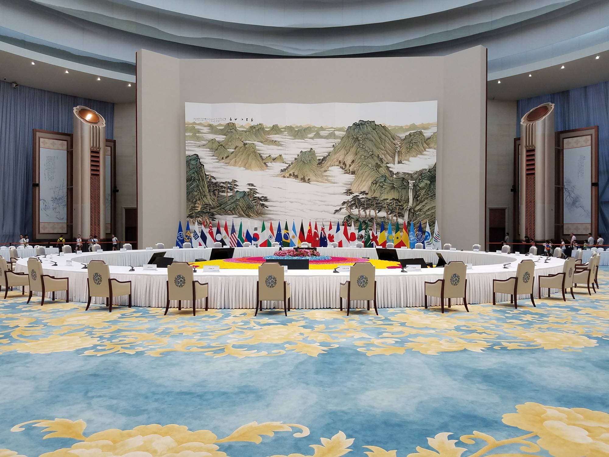International diplomatic conference room with flags and traditional artwork